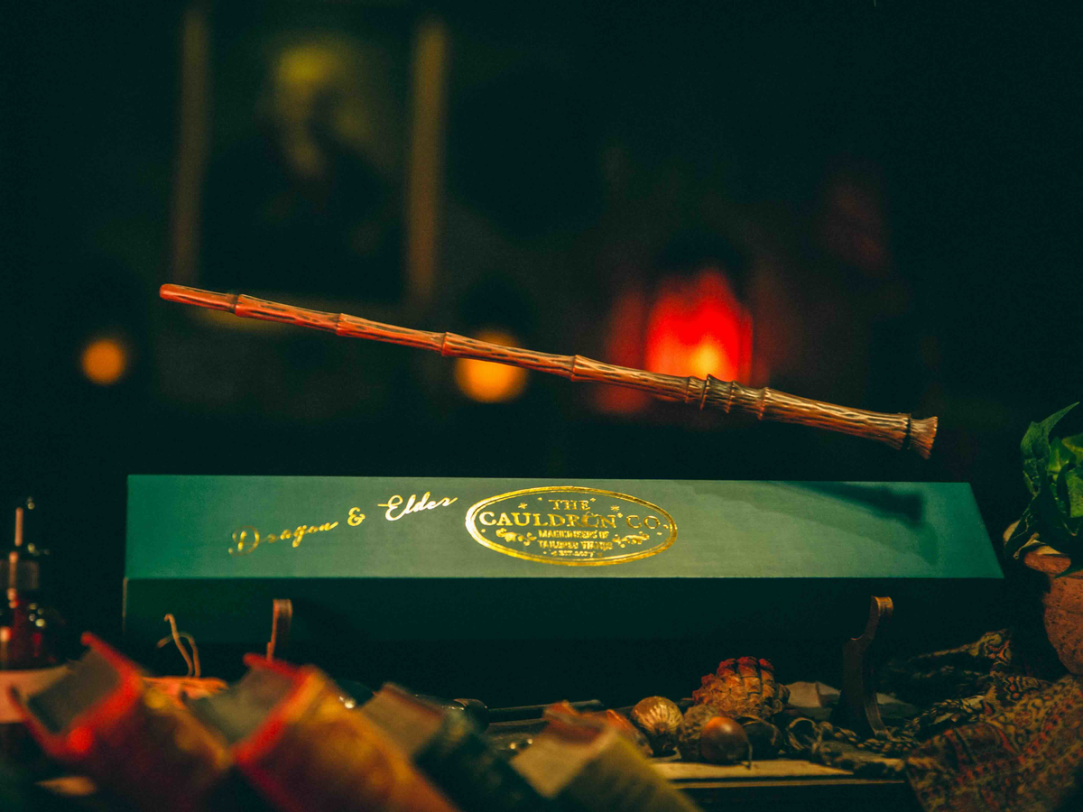 Dragon & Elder Magic Wand floating above its box, showcasing its magical properties and ancient design.